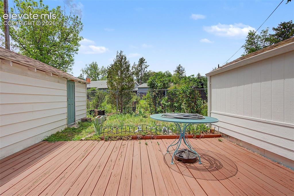 Image 24 of 26: Garage on left - shop on right.  Garden area at end of deck