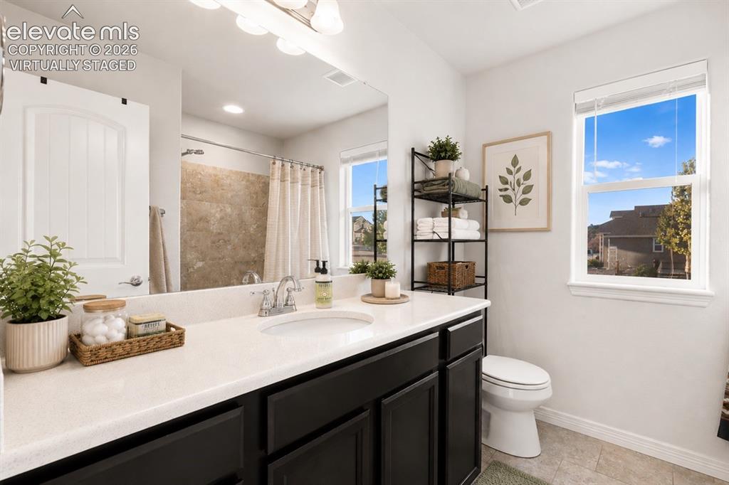 Image 44 of 48: Main Floor Bathroom Vanity with a white countertop and dark cabinetry, larg