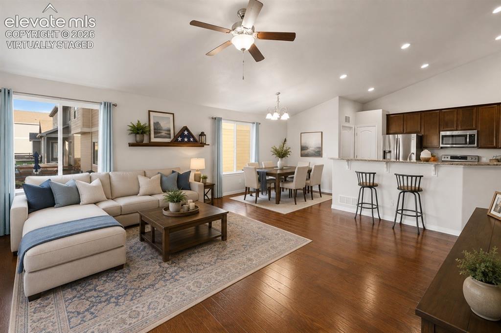 Image 46 of 48: Open-concept living space featuring wood-finish flooring, a contemporary ce