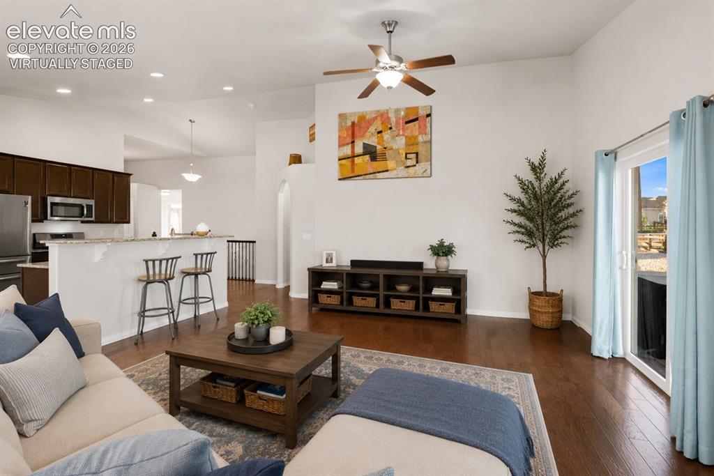 Image 48 of 48: Open-concept living area featuring wood-finish flooring, vaulted ceilings, 