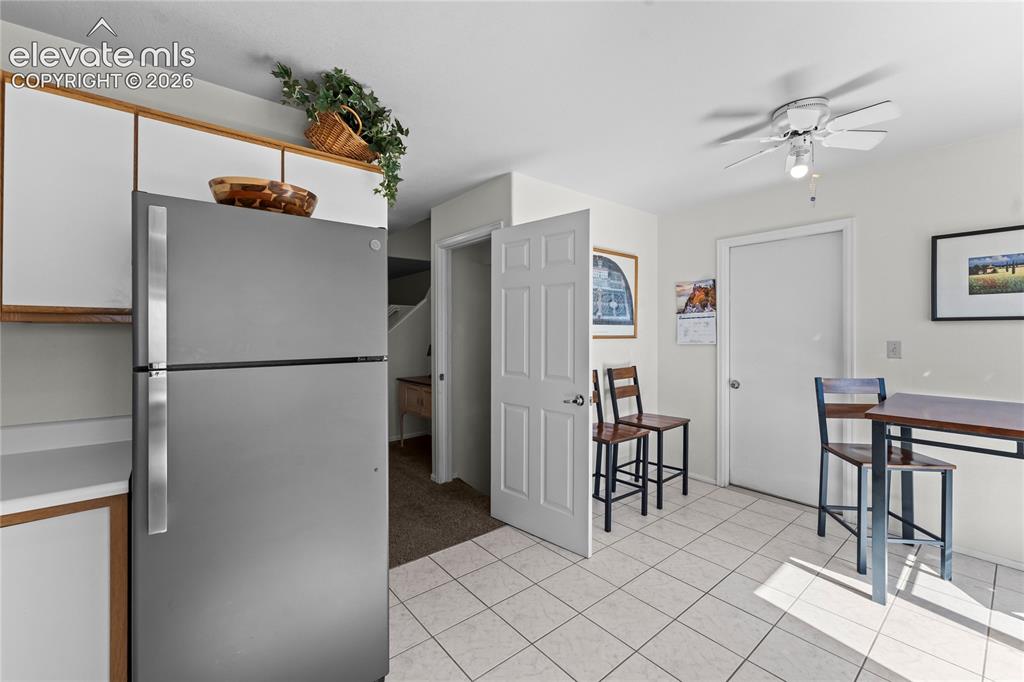 Image 11 of 43: White tile flooring, ceiling fan, white paneled doors, built-in cabinetry,