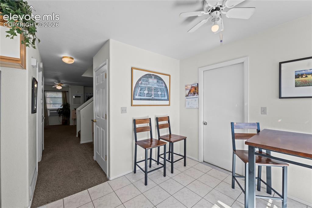 Image 13 of 43: White tile flooring, overhead ceiling fan, white paneled doors, and neutral