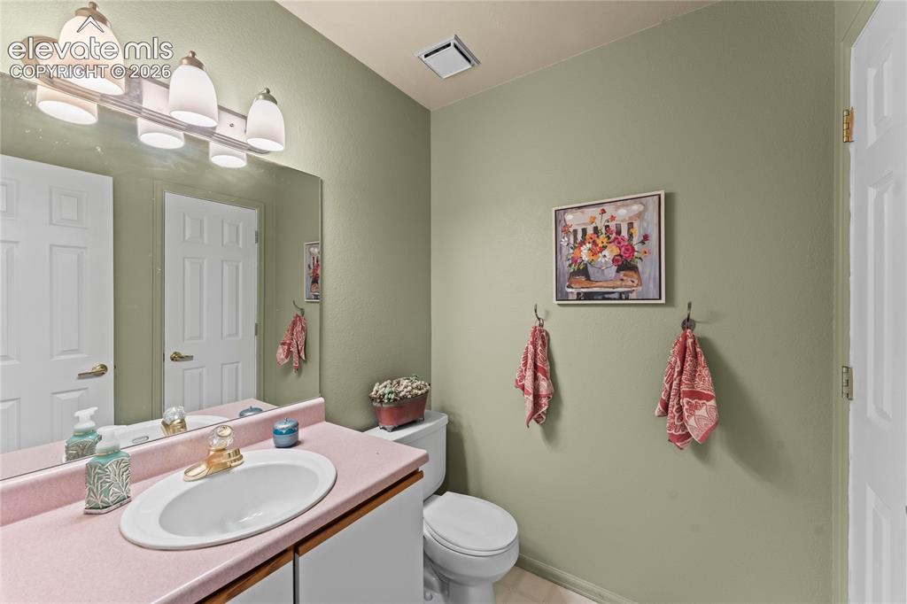 Image 19 of 43: Extended vanity countertop with an integrated basin sink, mirrored wall, an