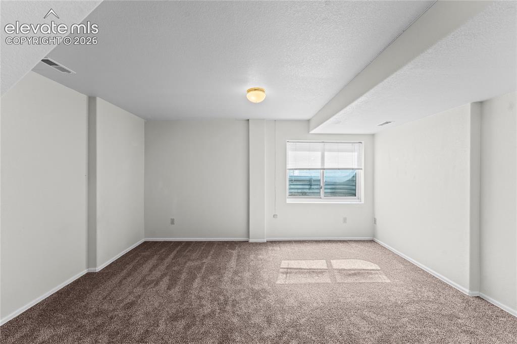 Image 22 of 43: Recessed window with blinds, overhead lighting, textured ceiling, and neutr