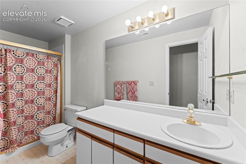 Image 29 of 43: Corner vanity with integrated sink, gold-tone faucet, and expansive wall-mo