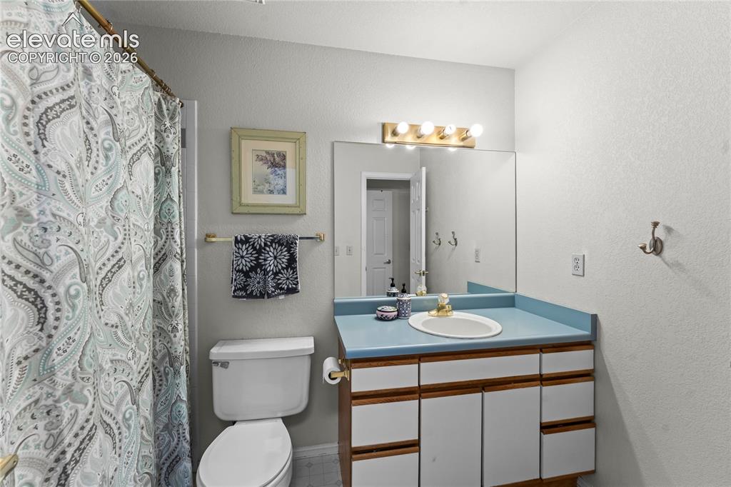 Image 32 of 43: Full vanity mirror with overhead bar lighting, single basin sink, and a woo