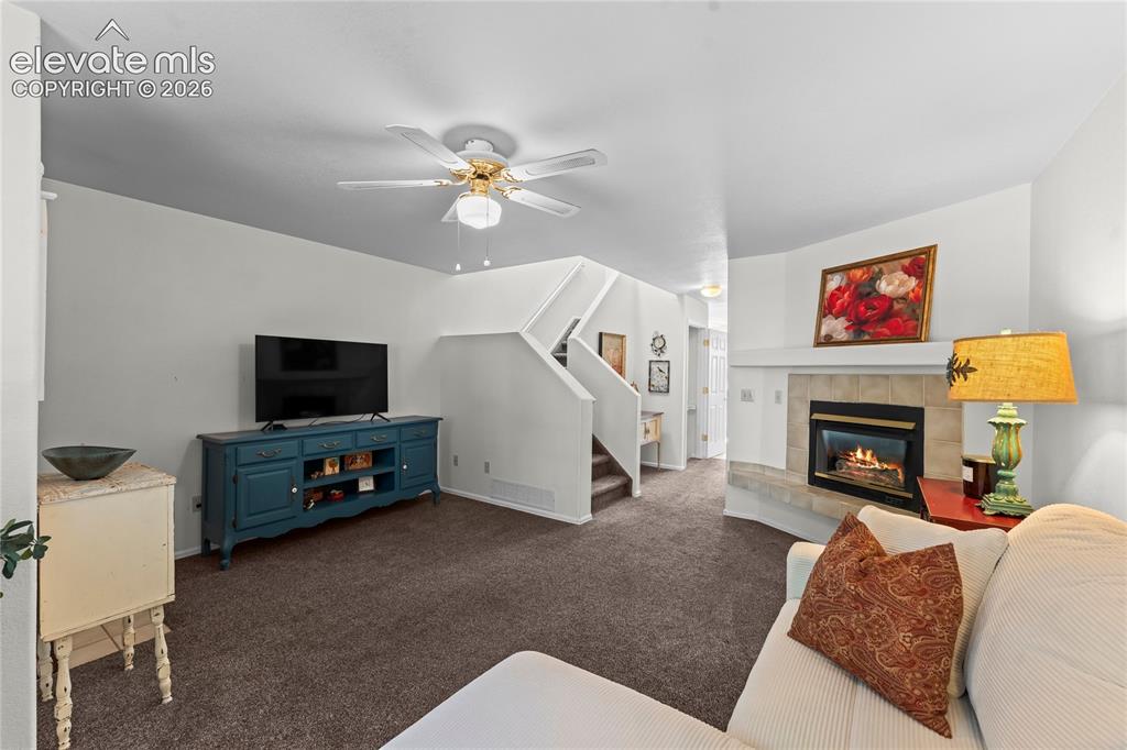 Image 4 of 43: Living area featuring a ceiling fan, carpet flooring, a gas fireplace with 
