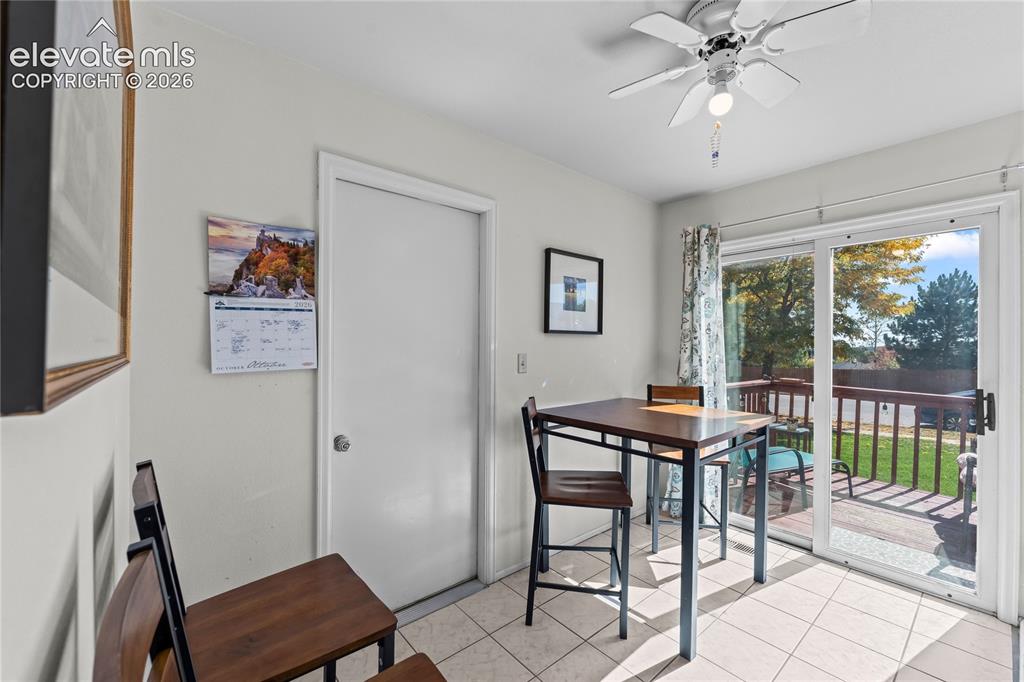 Image 9 of 43: White tiled flooring, ceiling fan with light fixture, sliding glass door, a