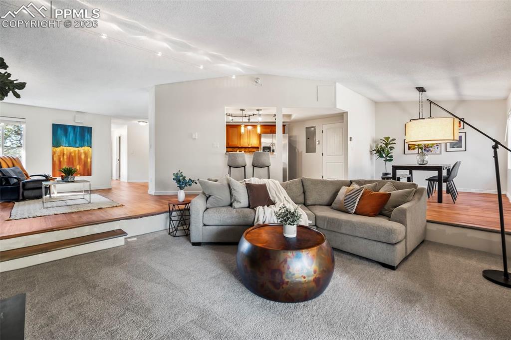 Image 6 of 39: Sunken living room anchored by a wood-burning fireplace, creating a warm fo