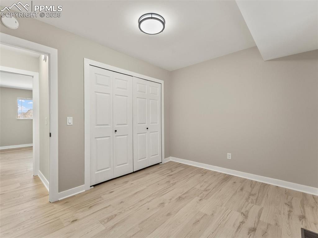 Image 28 of 36: Unfurnished bedroom featuring light wood finished floors and a closet