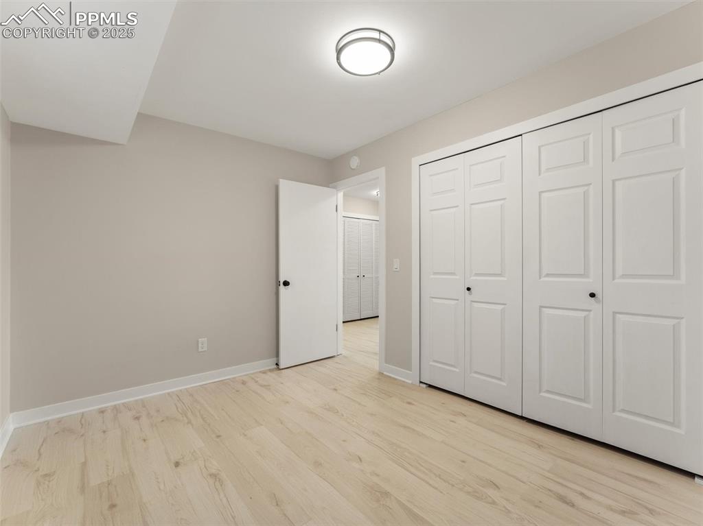 Image 29 of 36: Unfurnished bedroom with light wood-style flooring and a closet