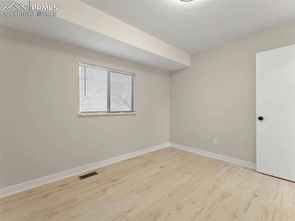Image 30 of 36: Empty room with light wood-type flooring and baseboards