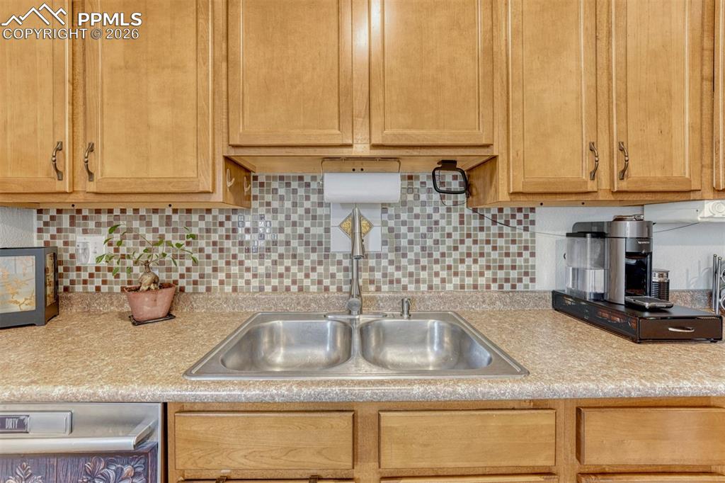 Image 10 of 42: Kitchen sink with double basin and a mosaic tile backsplash