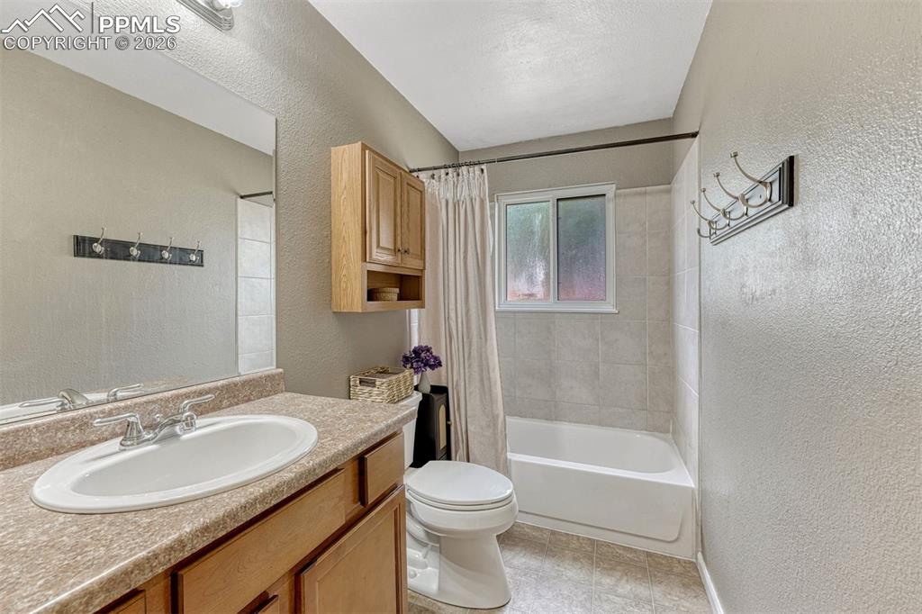 Image 13 of 42: Bathroom featuring a vanity with a laminate countertop and integrated sink,