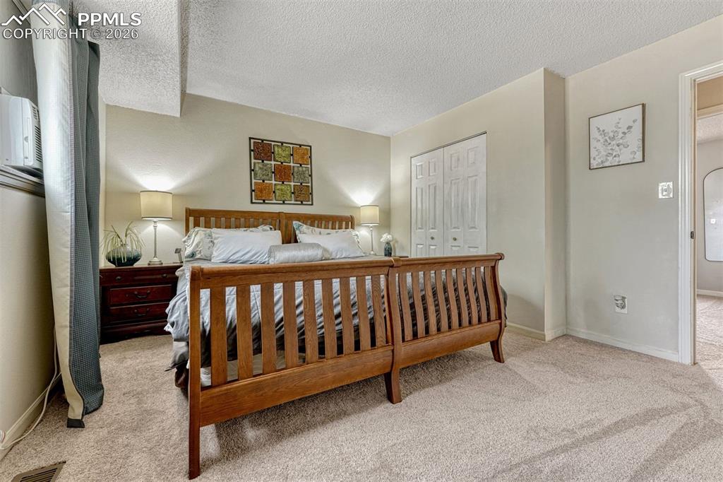 Image 15 of 42: Carpeted bedroom with neutral wall tones