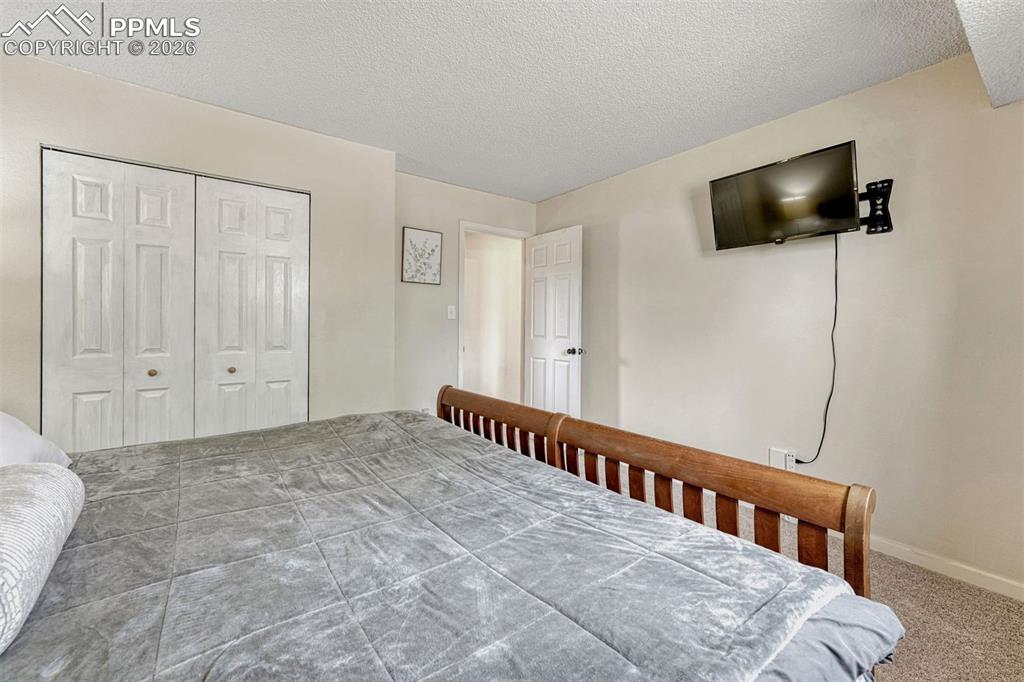 Image 16 of 42: Bedroom with neutral wall tones and carpeted flooring