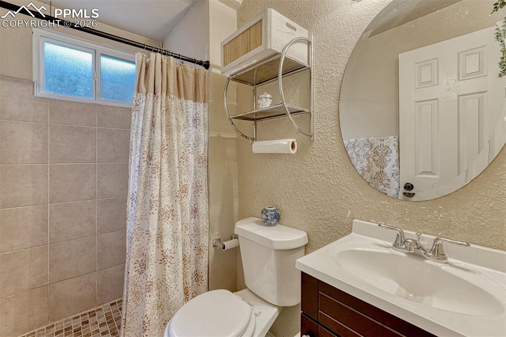 Image 23 of 42: Bathroom featuring a dark wood-finish vanity with a white countertop and in