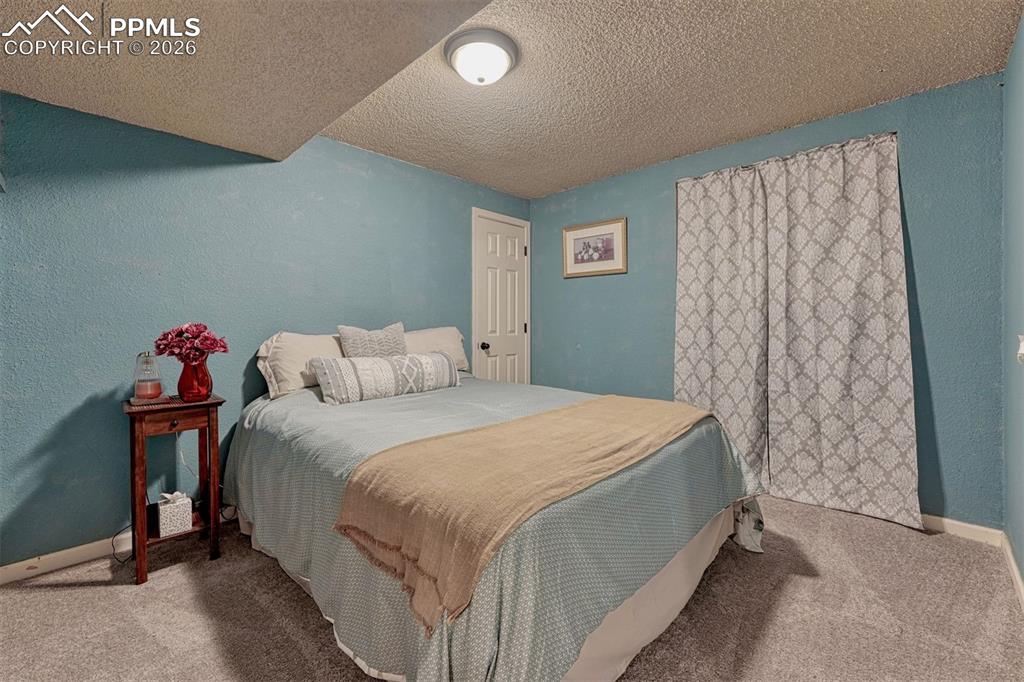 Image 26 of 42: Carpeted room featuring a white door, light blue textured walls, and a rece