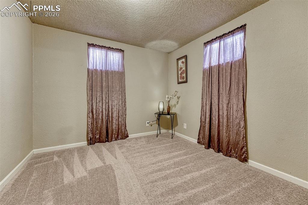 Image 29 of 42: Carpeted room with neutral wall tones and white baseboards