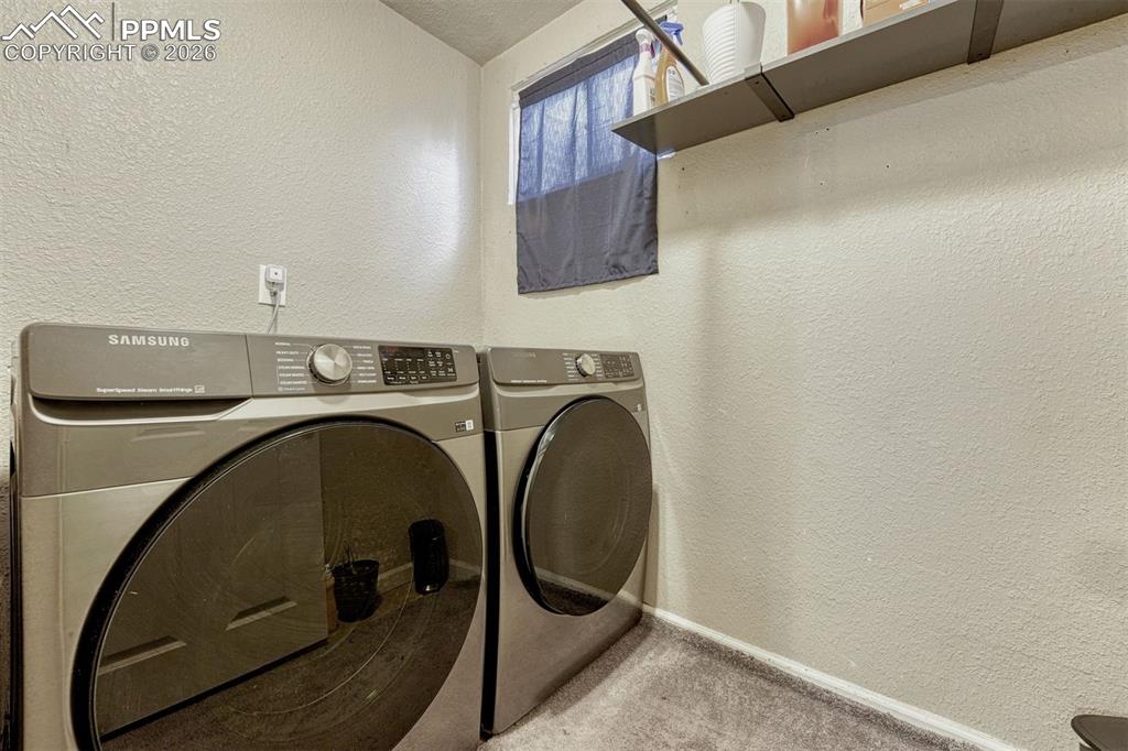 Image 30 of 42: Dedicated laundry area featuring textured walls, a recessed window, and a b