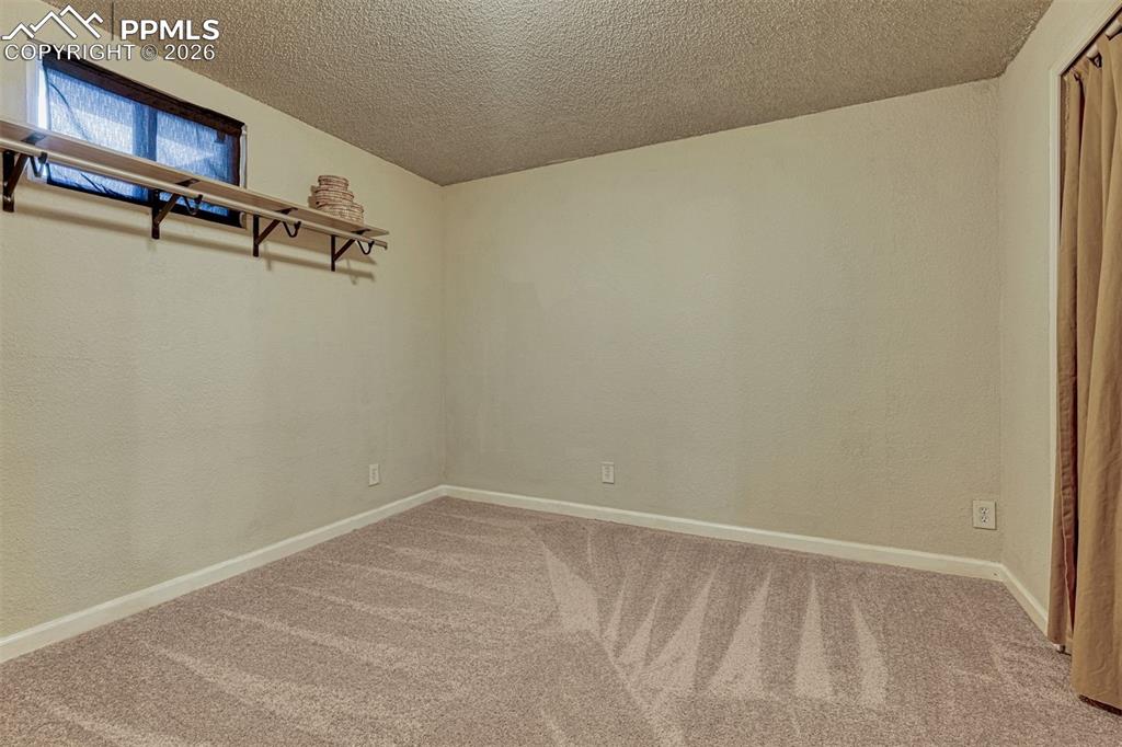Image 31 of 42: Room featuring textured walls, neutral carpet flooring, and a low-profile w