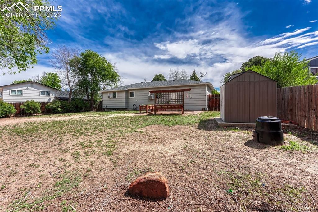 Image 37 of 42: Expansive backyard featuring a large open area, a detached storage shed on 