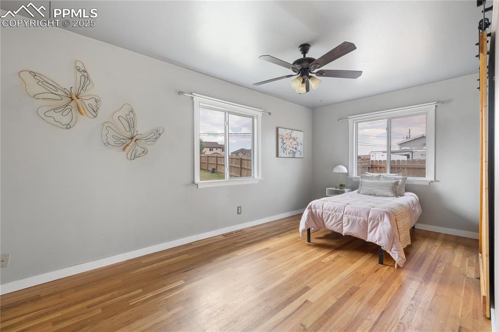 Image 20 of 35: Bedroom with barn-style closet doors