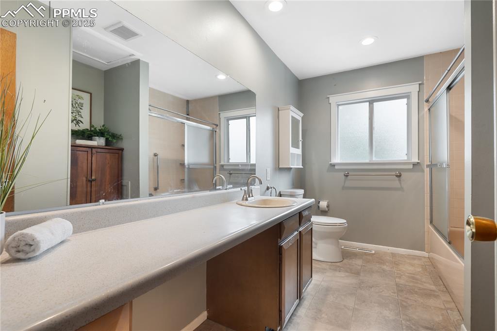 Image 21 of 35: Spacious bathroom with long vanity