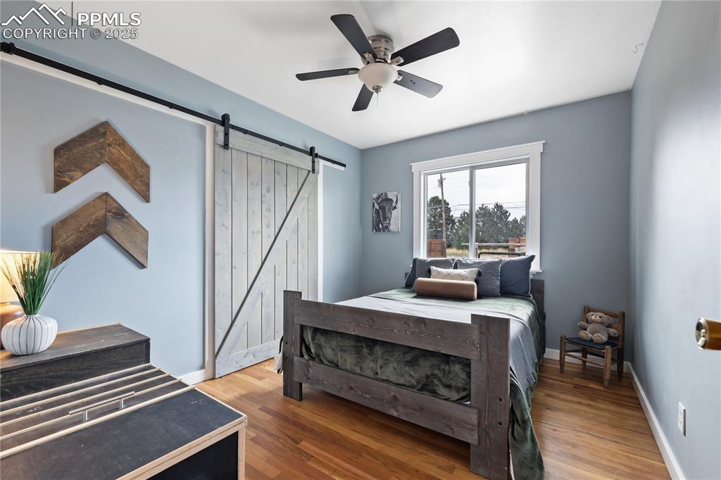 Image 23 of 35: Cozy bedroom with barn door closet