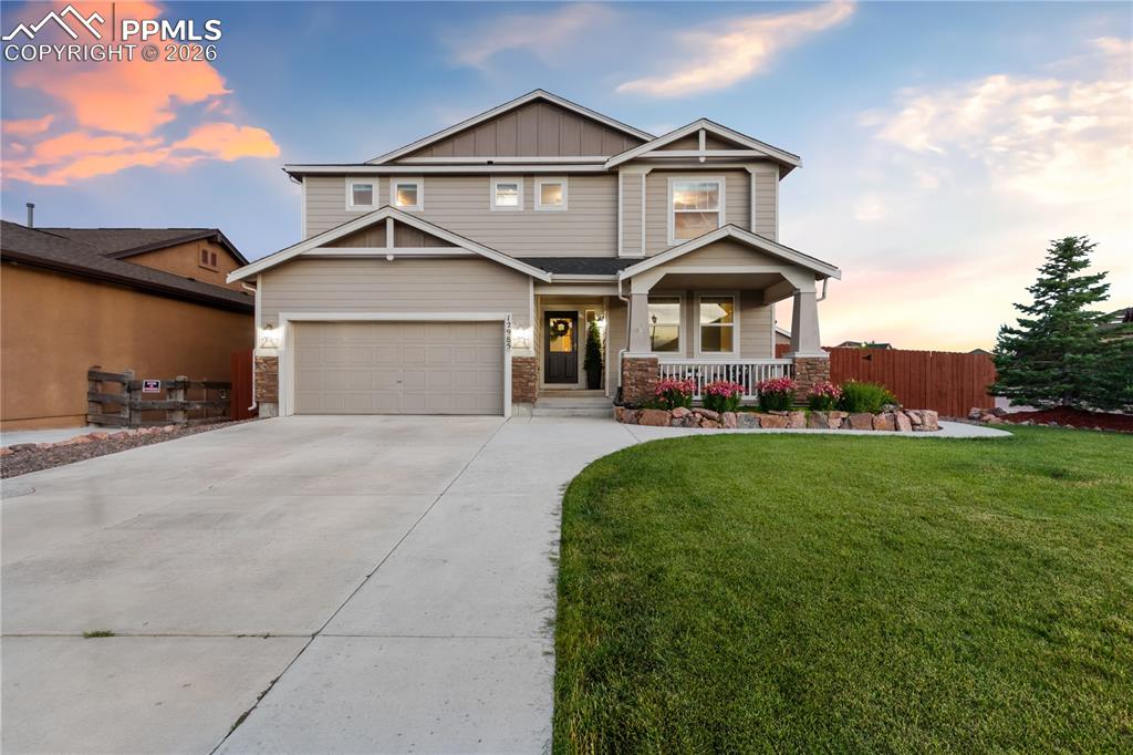 Image 1 of 50: Craftsman house with board and batten siding, covered porch, and driveway
