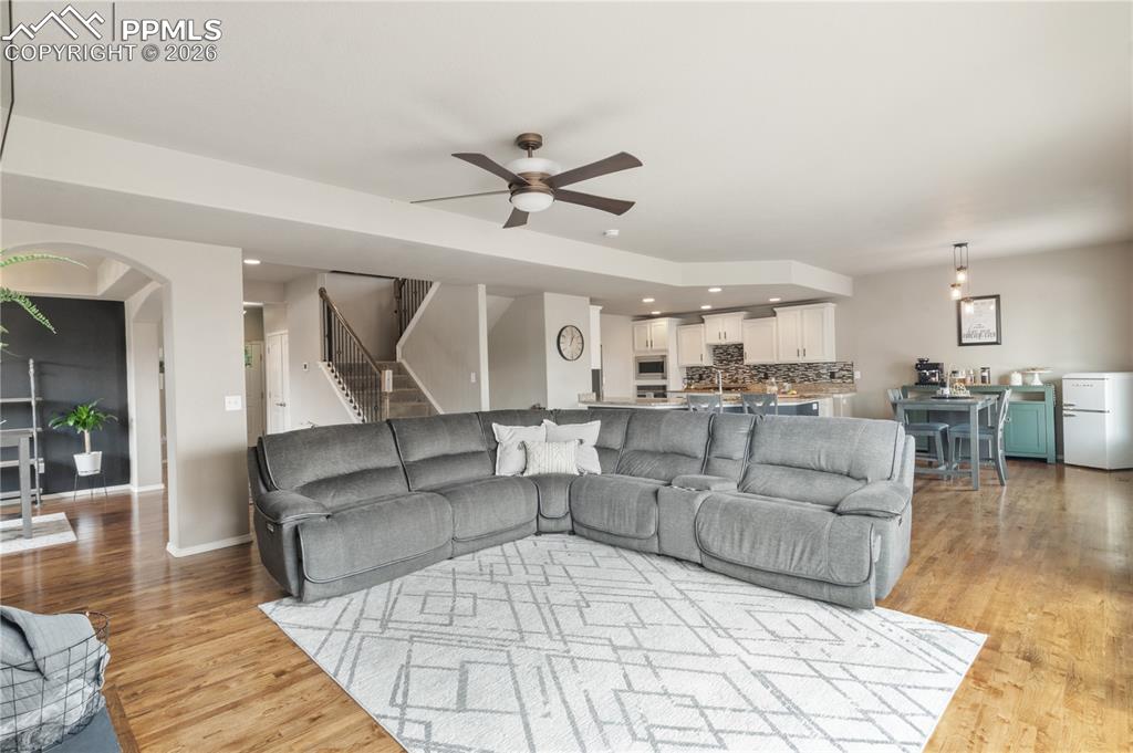 Image 10 of 50: Living room with ceiling fan, recessed lighting, arched walkways, and light