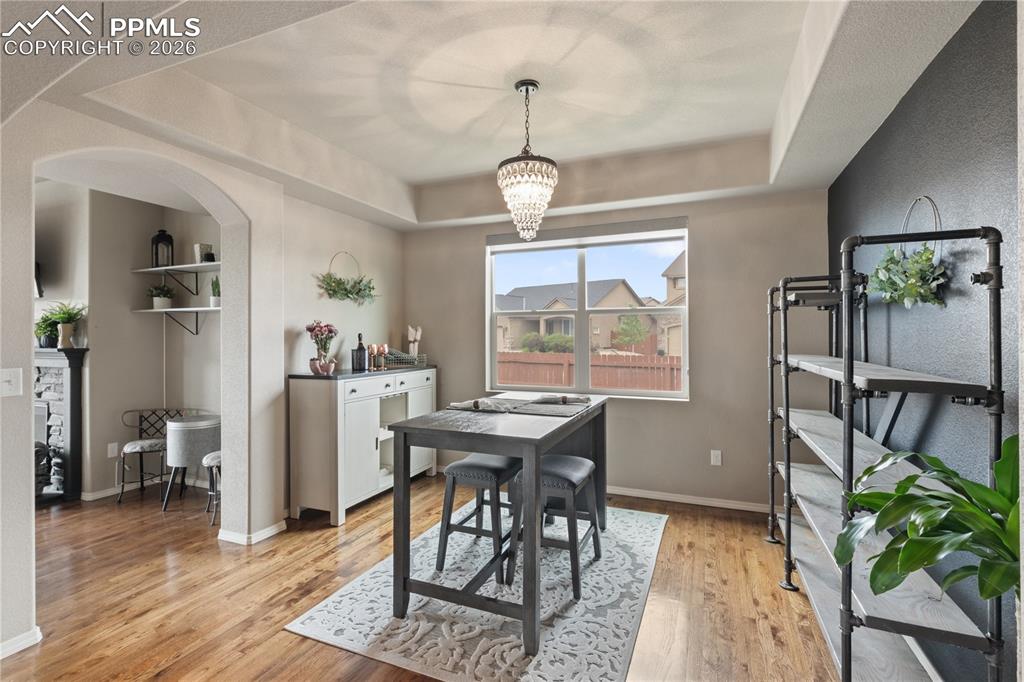 Image 14 of 50: Dining area with a raised ceiling, light wood-type flooring, a chandelier, 