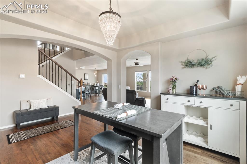 Image 15 of 50: Dining room featuring arched walkways, suspended lighting, a raised ceiling