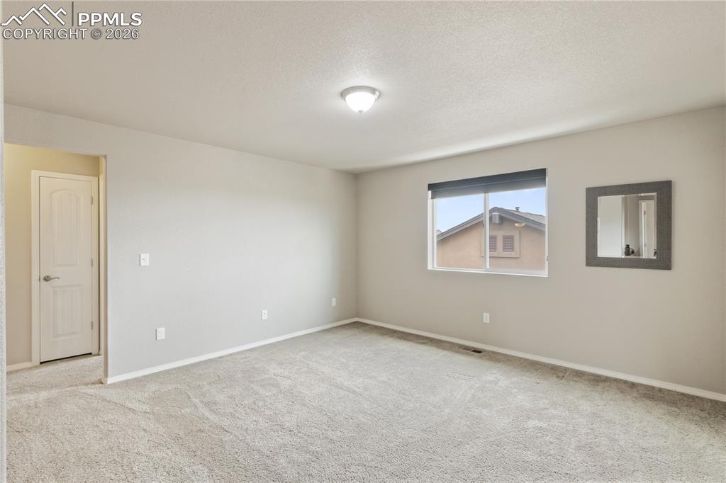 Image 30 of 50: Unfurnished room featuring light colored carpet and a textured ceiling