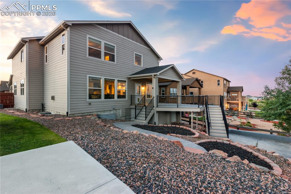 Image 4 of 50: View of front of property with board and batten siding and a deck