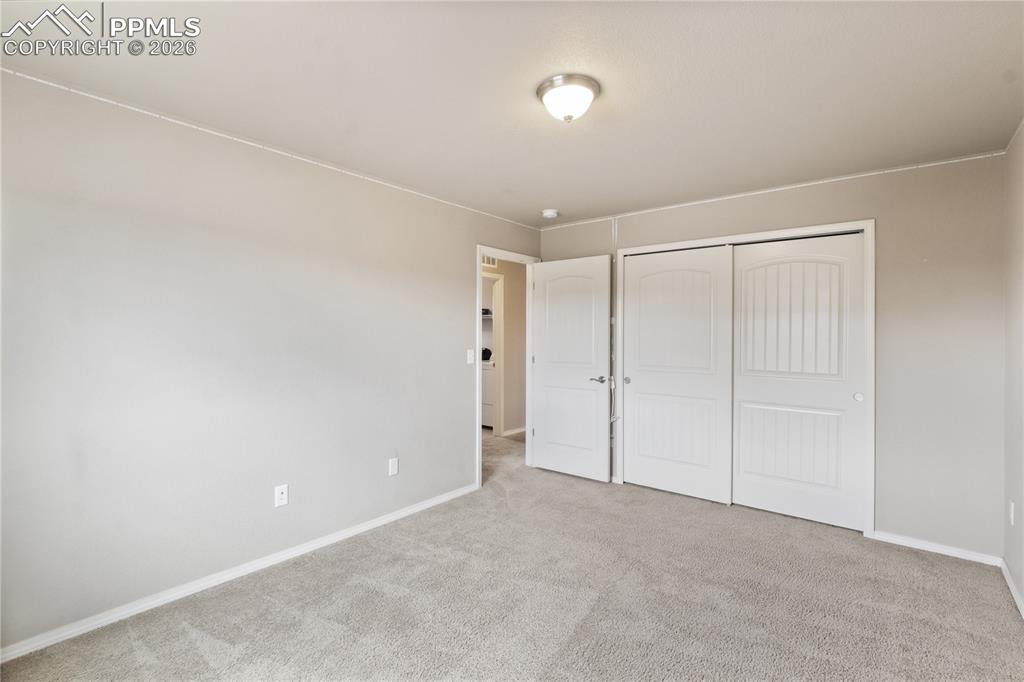 Image 41 of 50: Bedroom featuring light colored carpet and a closet