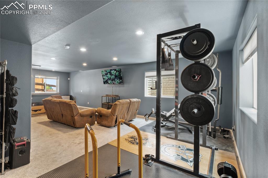 Image 43 of 50: Exercise room with light carpet, a textured ceiling, and recessed lighting