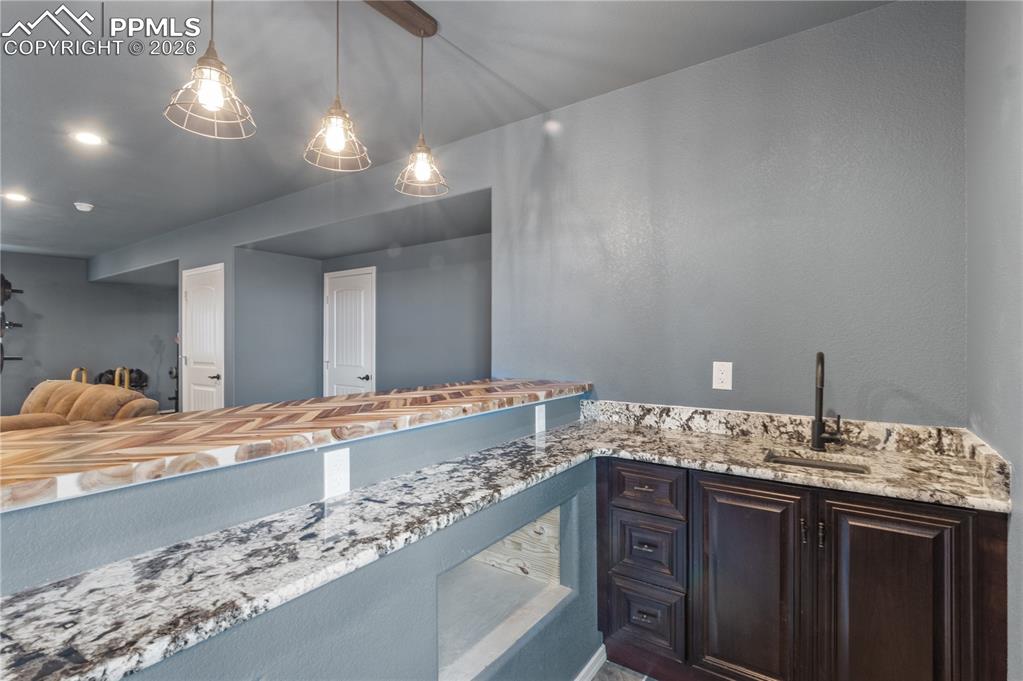 Image 45 of 50: Kitchenette with space for a microwave, a bar sink, and recessed lighting