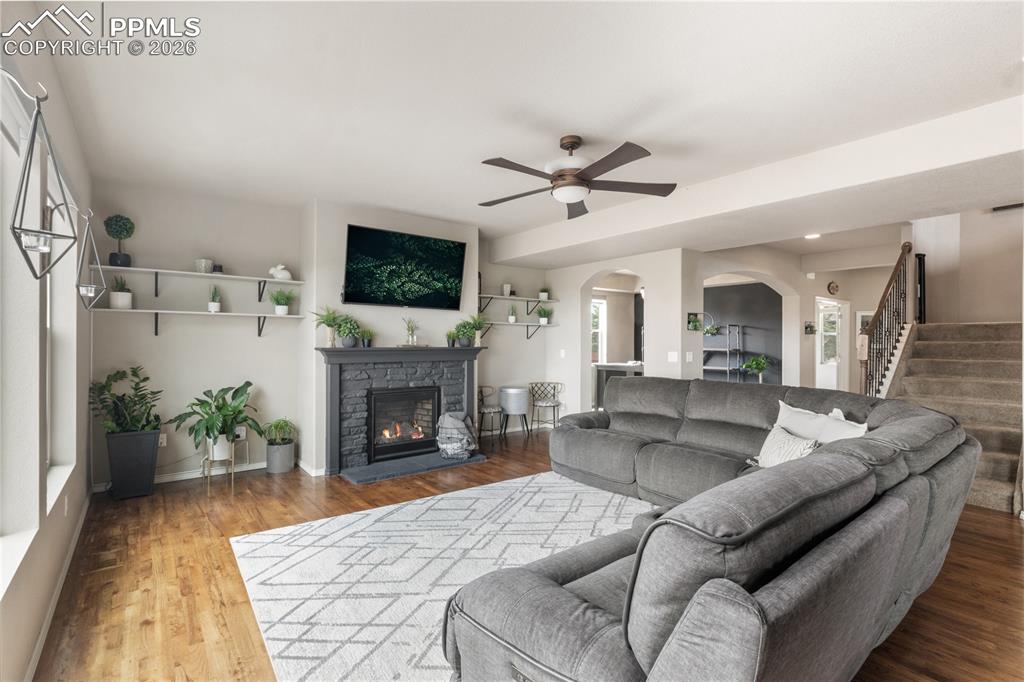 Image 8 of 50: Living room featuring arched walkways, ceiling fan, light wood finished flo