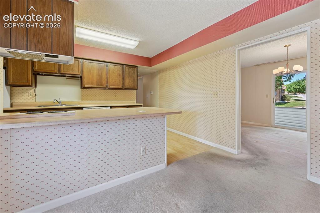 Image 10 of 24: Plenty of cabinet space, breakfast bar, and a double basin sink