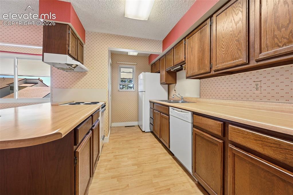 Image 11 of 24: Kitchen with extensive wood-finish cabinetry, light wood-finish countertops