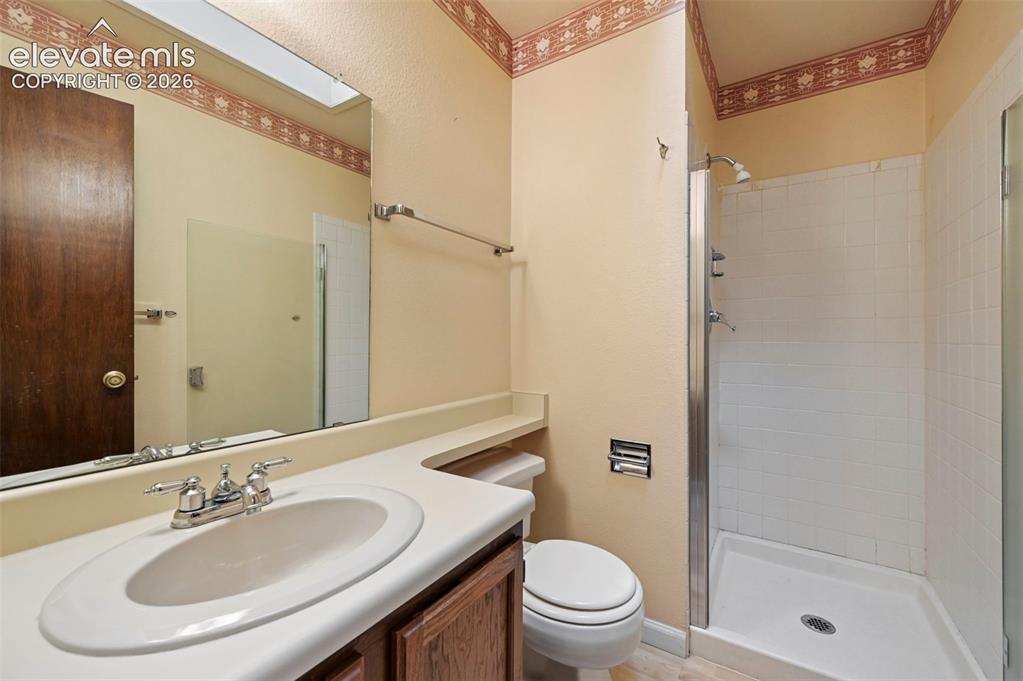 Image 14 of 24: Bathroom with enclosed shower with white tile surround