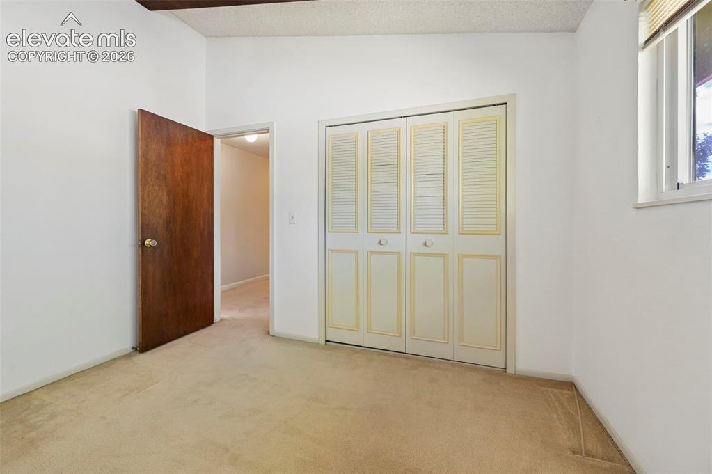 Image 20 of 24: Carpeted flooring, white walls, wood-finish interior door, bifold closet do