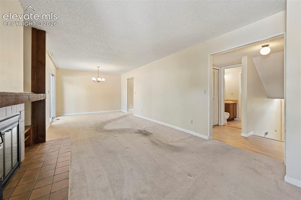 Image 6 of 24: Fireplace with tile hearth and wood mantel opens to dining area