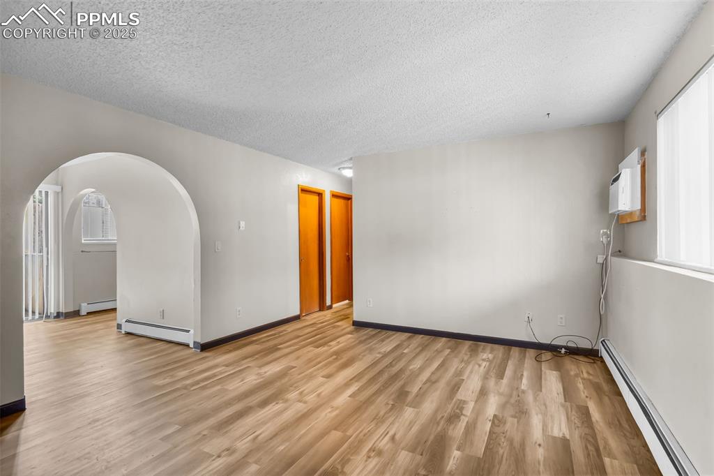 Image 13 of 26: Spare room featuring healthy amount of natural light, a baseboard heating u