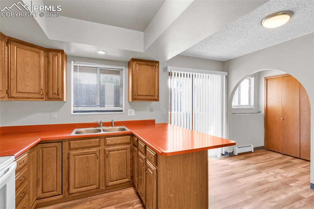 Image 18 of 26: Kitchen with a peninsula, healthy amount of natural light, light wood finis