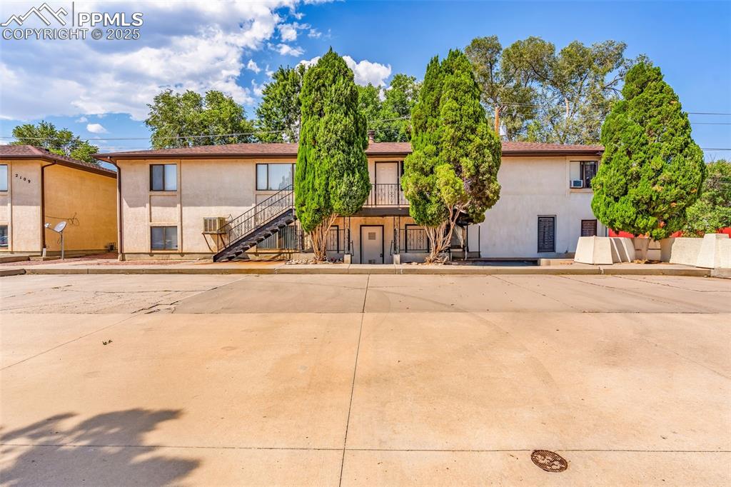 Image 6 of 26: View of front of home featuring stucco siding and stairway