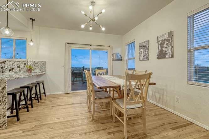 Image 10 of 44: Dining Area with sliding door out to the deck. Breakfast bar with marble co