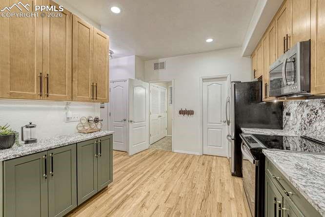 Image 13 of 44: Kitchen with new cabinets, hardwood, new range. 