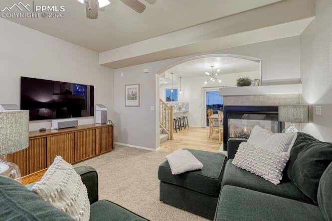 Image 8 of 44: Living Room, carpeted with fireplace and open concept into the dining room.